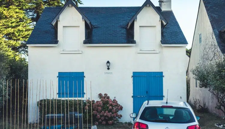 blue and white concrete house with blue metal gate